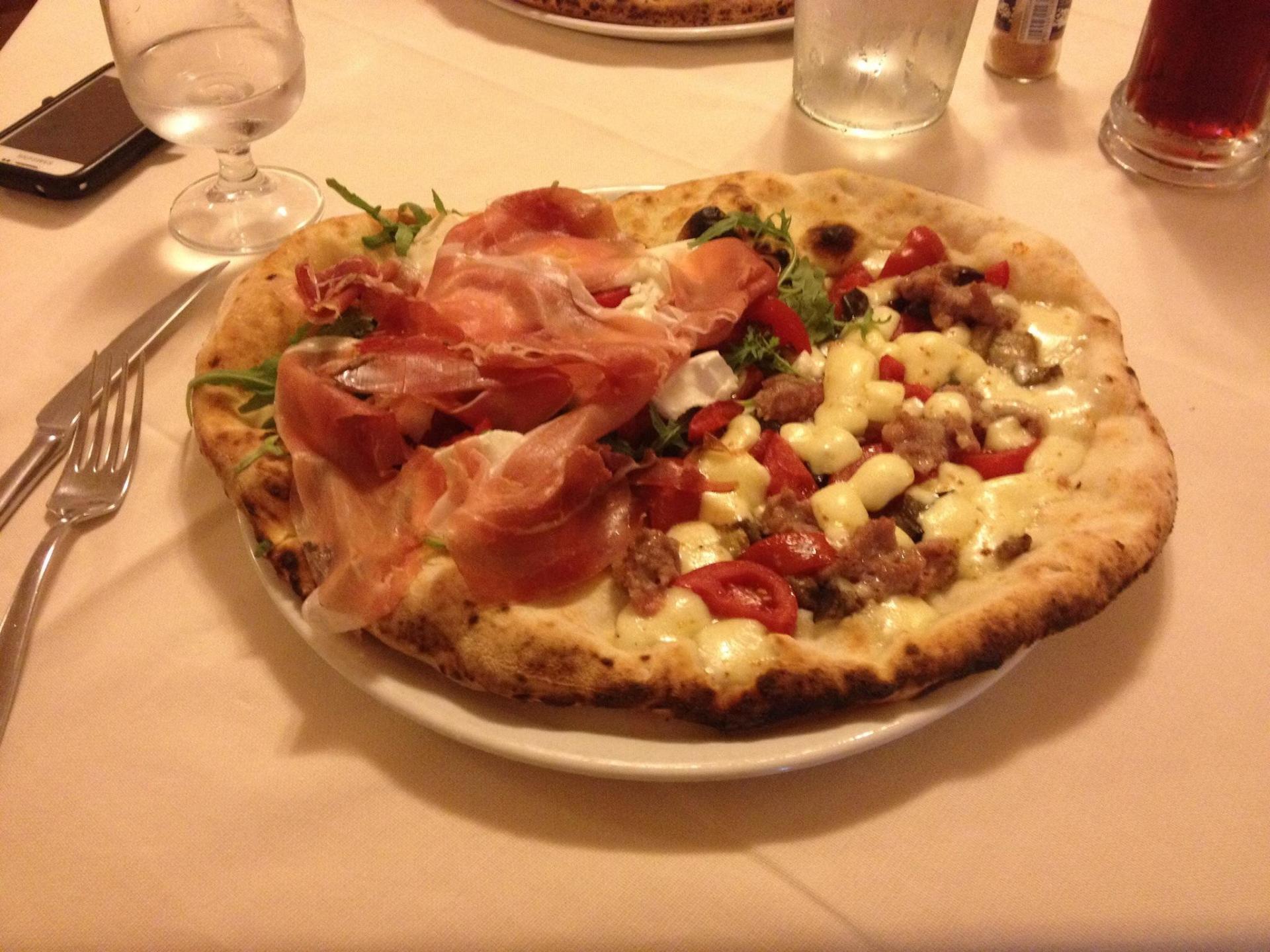 pizza con prosciutto crudo, pomodorini e salsiccia
