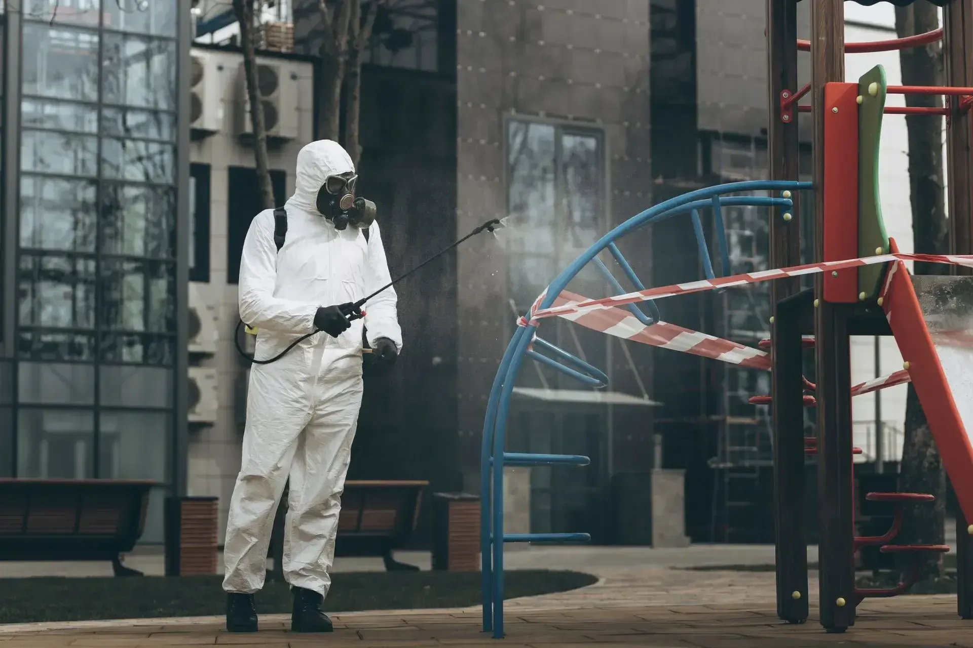 A pest control professional sprays a playground