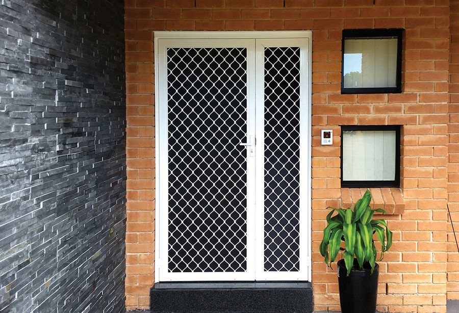 Diamond grille security door with side panel on suburban house