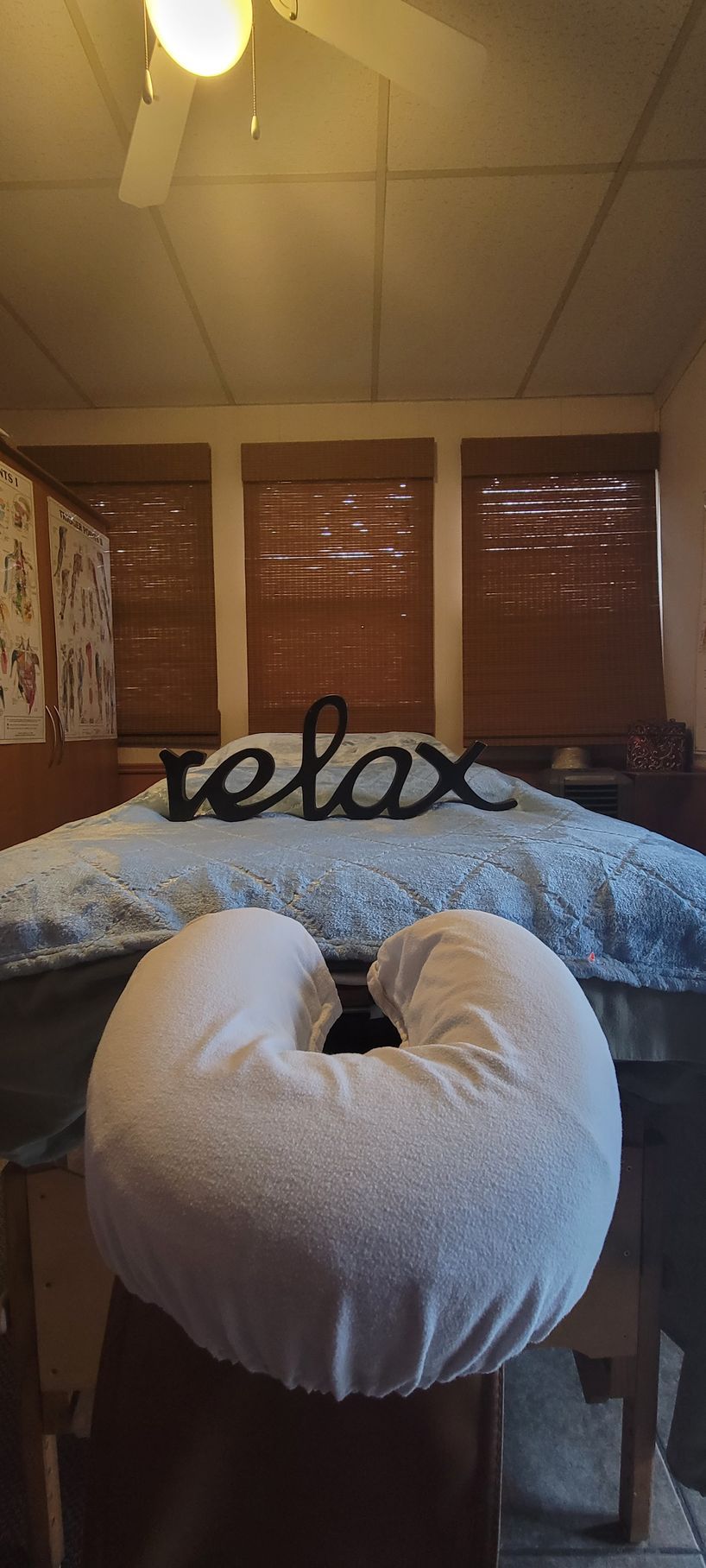 A massage table with a pillow and a sign that says relax on it.
