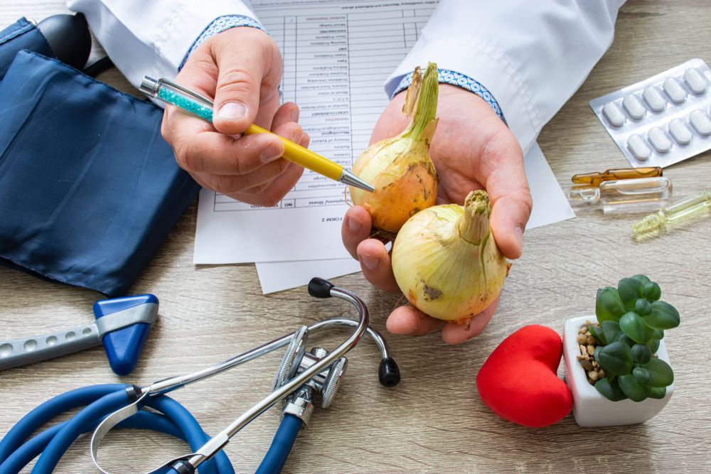 A doctor is holding two onions in his hands and pointing at them.