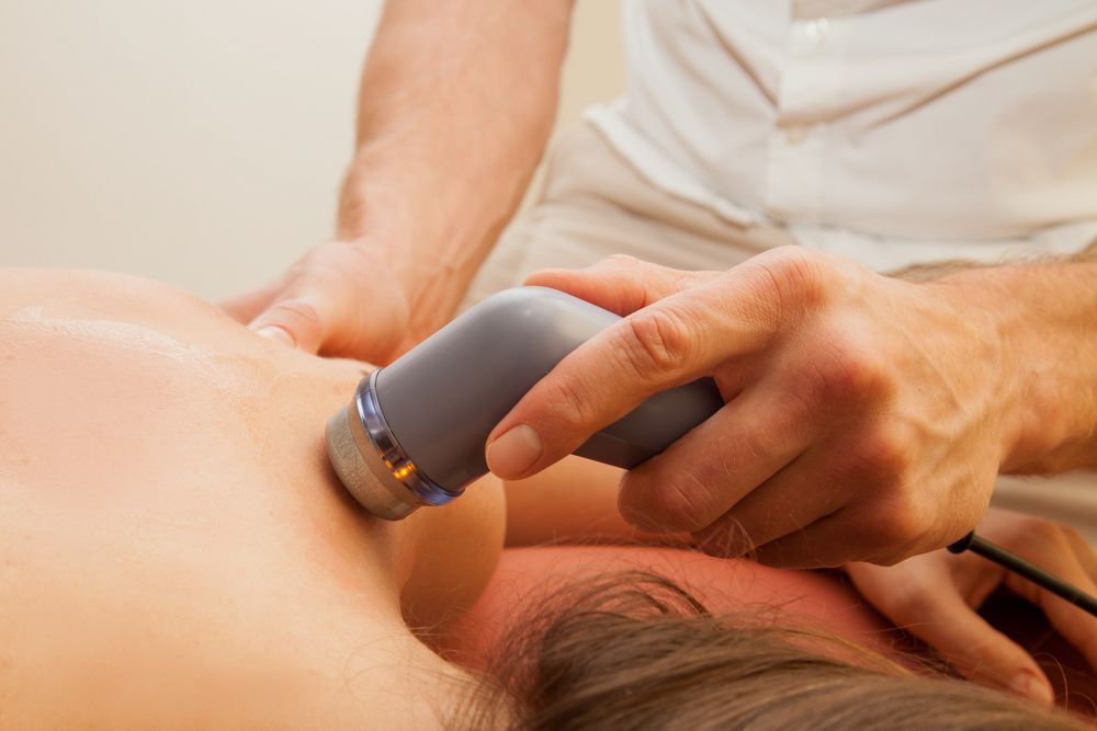 A person is getting an ultrasound treatment on their back.
