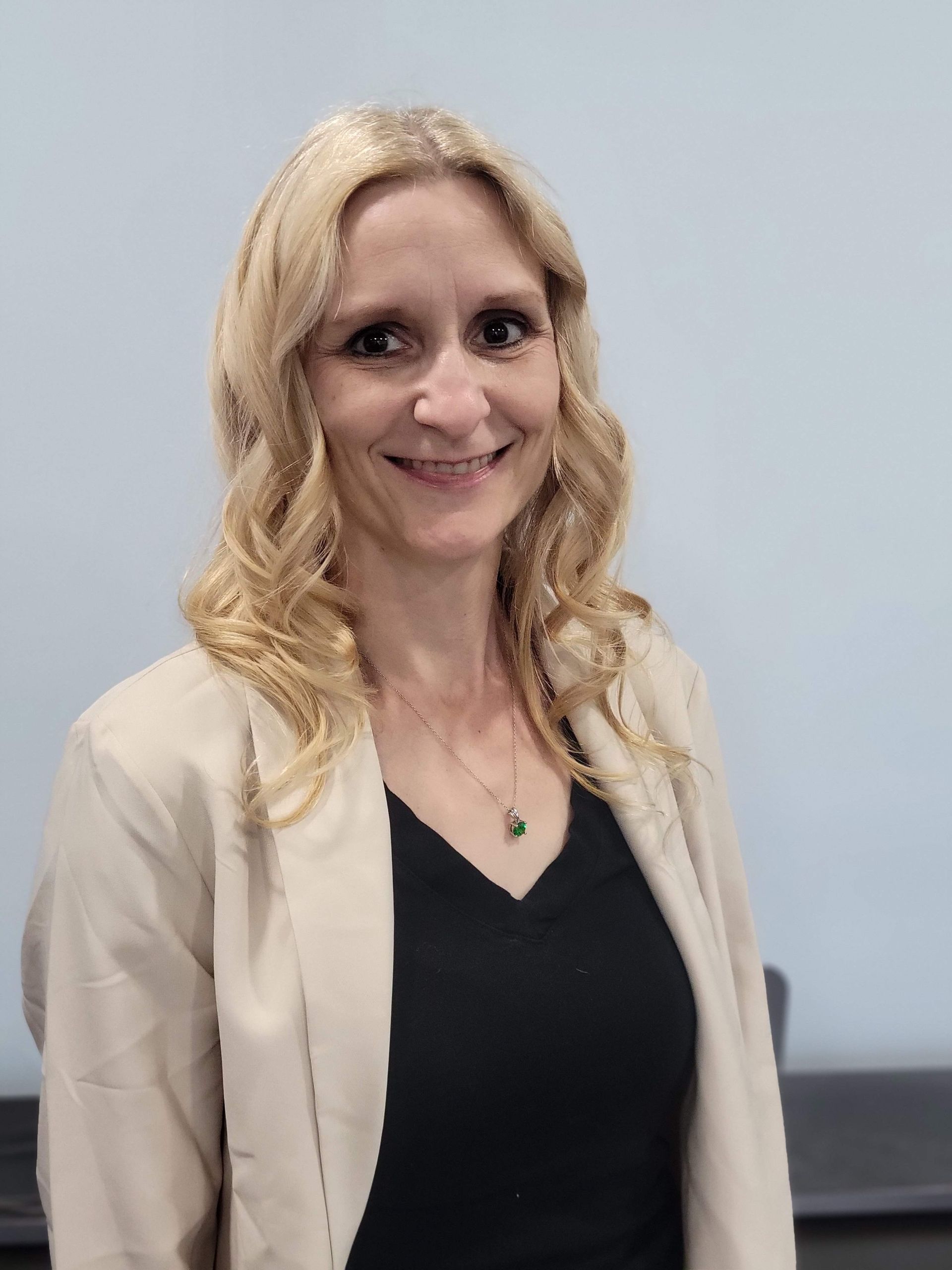 A living room with a couch and a wooden table with a vase of flowers on it.