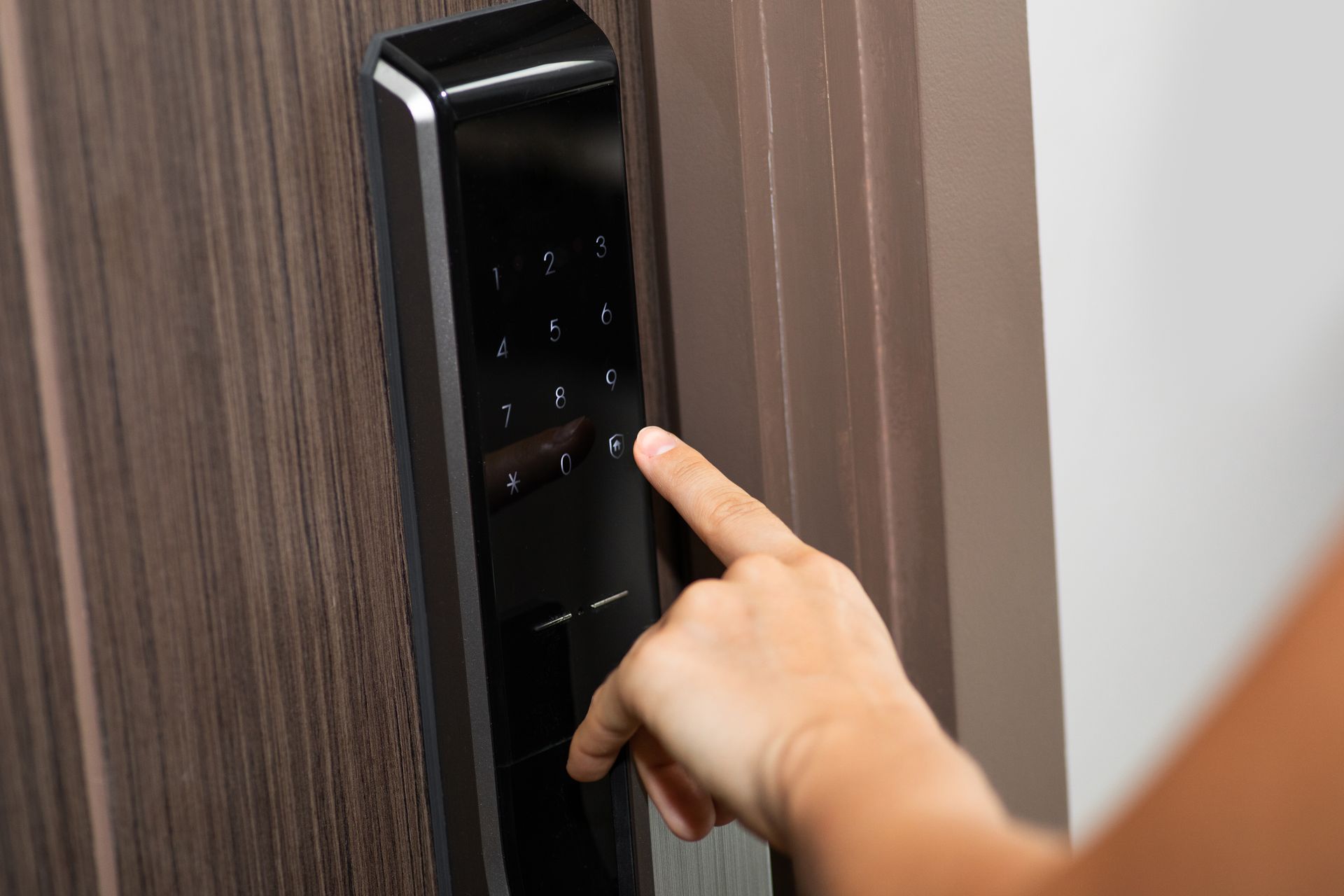 Hand and digital smart code lock on the door of a modern apartment.