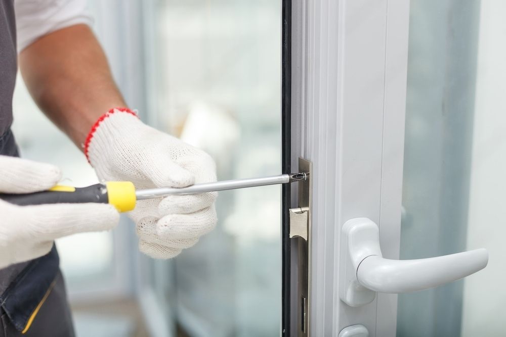 A skilled male locksmith expertly installing new doors in a recently constructed building.