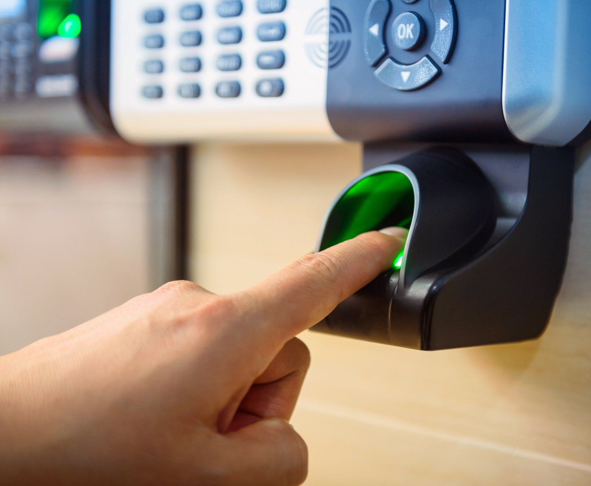 A person is pressing a button on a fingerprint scanner.