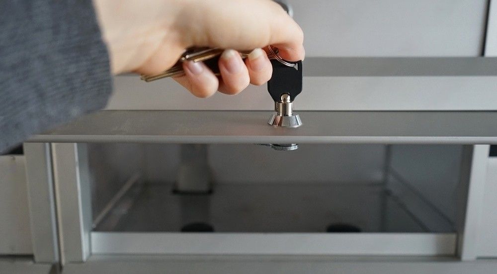 Female hand holding keys and opening an empty metal mailbox.