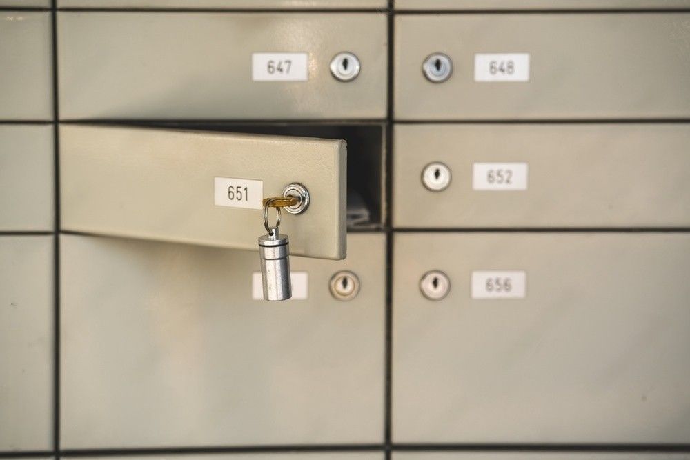 A key inserted into the lock of an open mailbox.