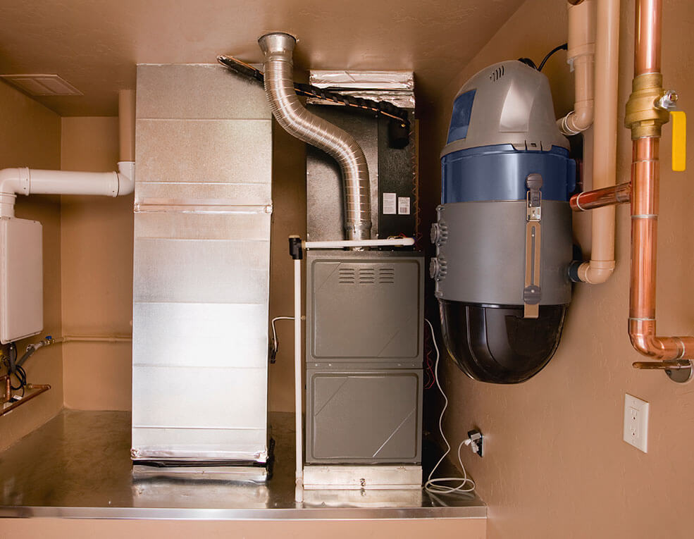 Furnace, ductwork, and central vacuum unit installed in a utility room.