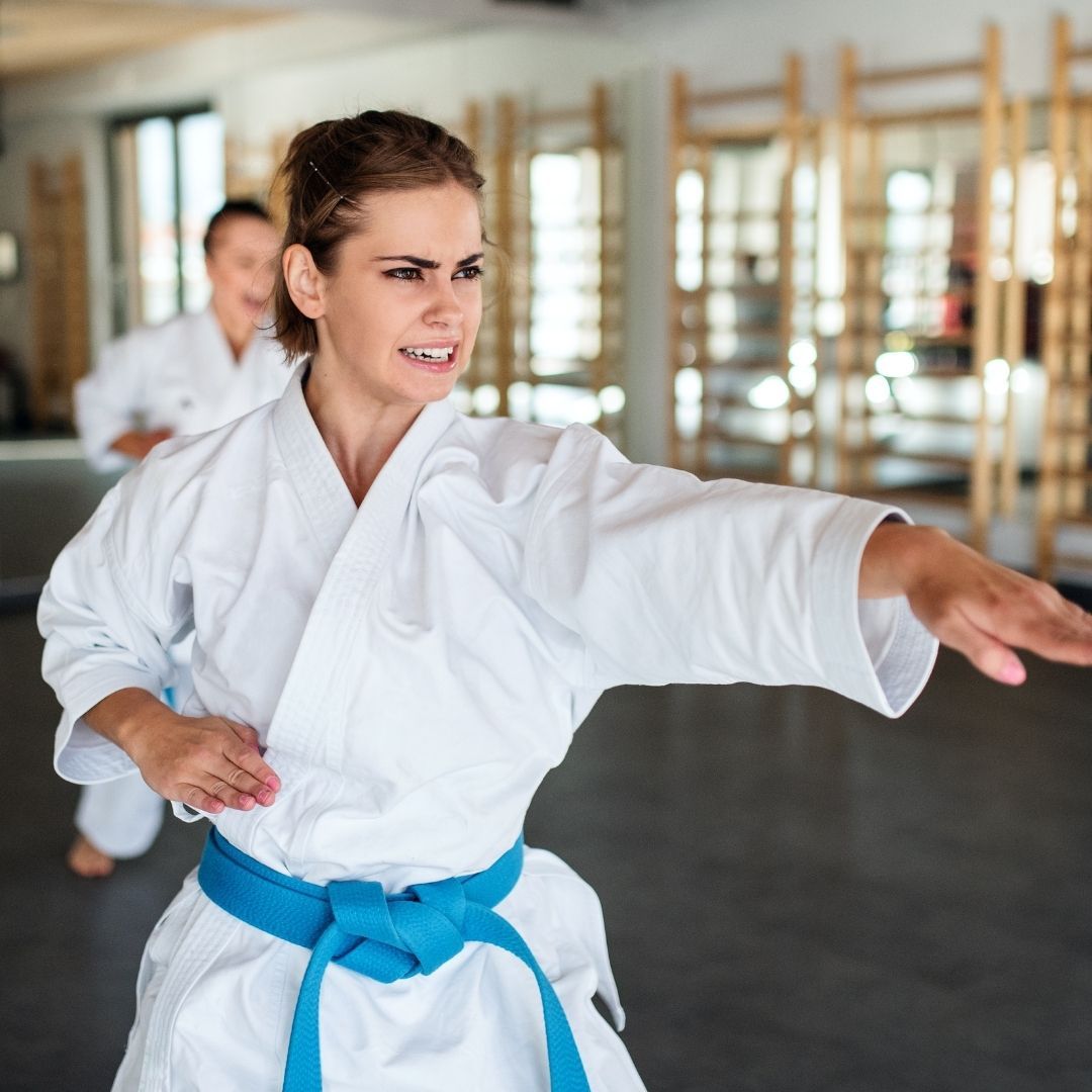A group of men are practicing karate in a gym.