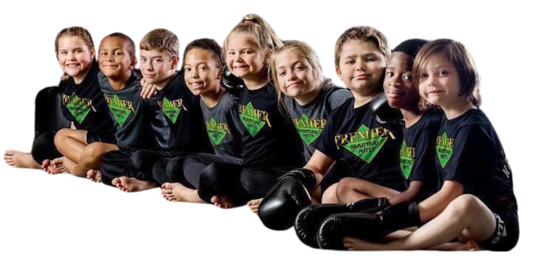 A group of kids in karate uniforms are sitting on the floor drinking water