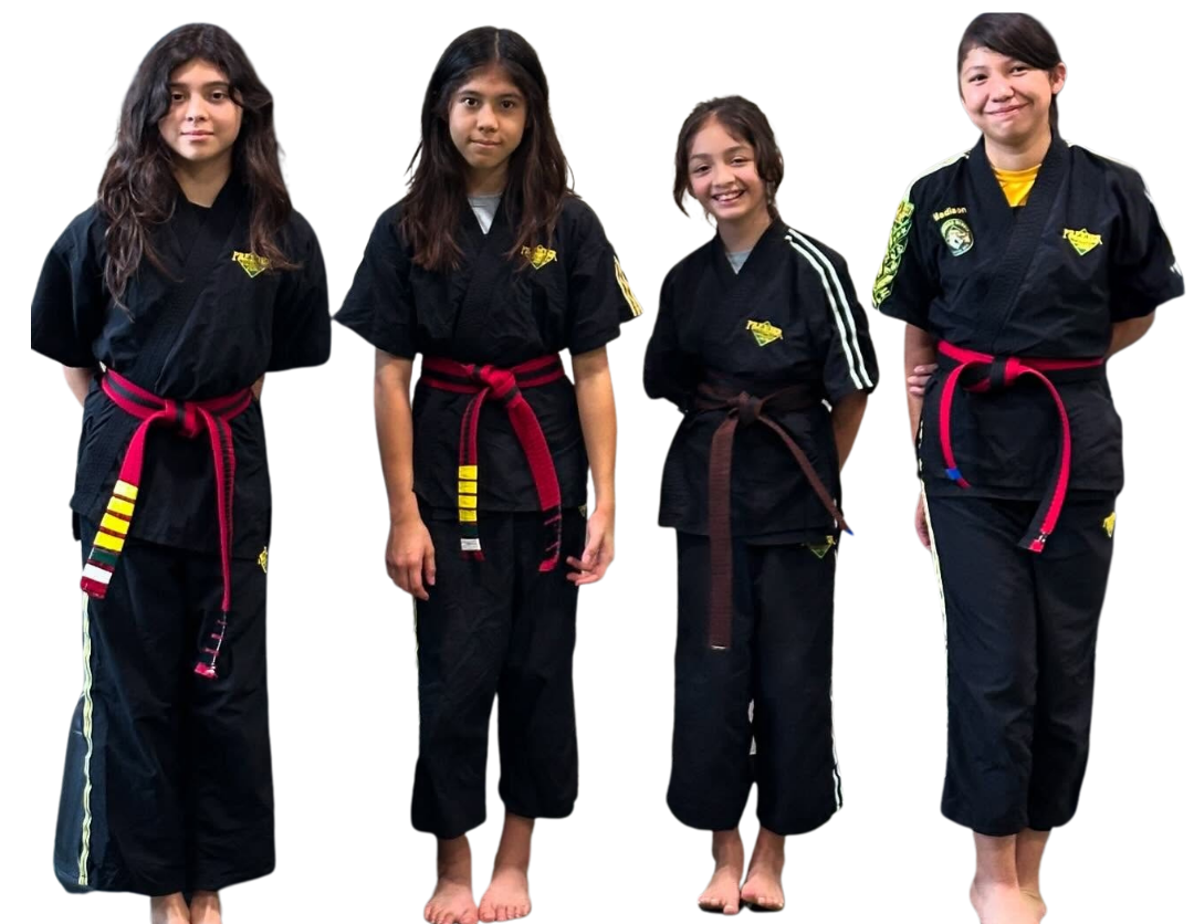 A group of kids in karate uniforms are sitting on the floor drinking water