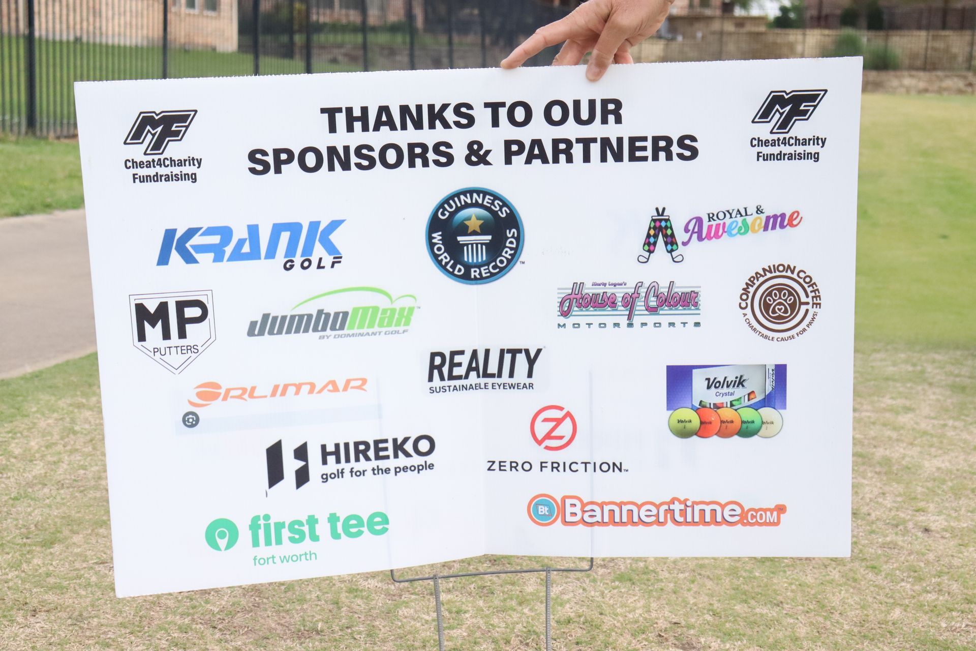 Sign thanking sponsors at an outdoor event; logos of various businesses and organizations are displayed.