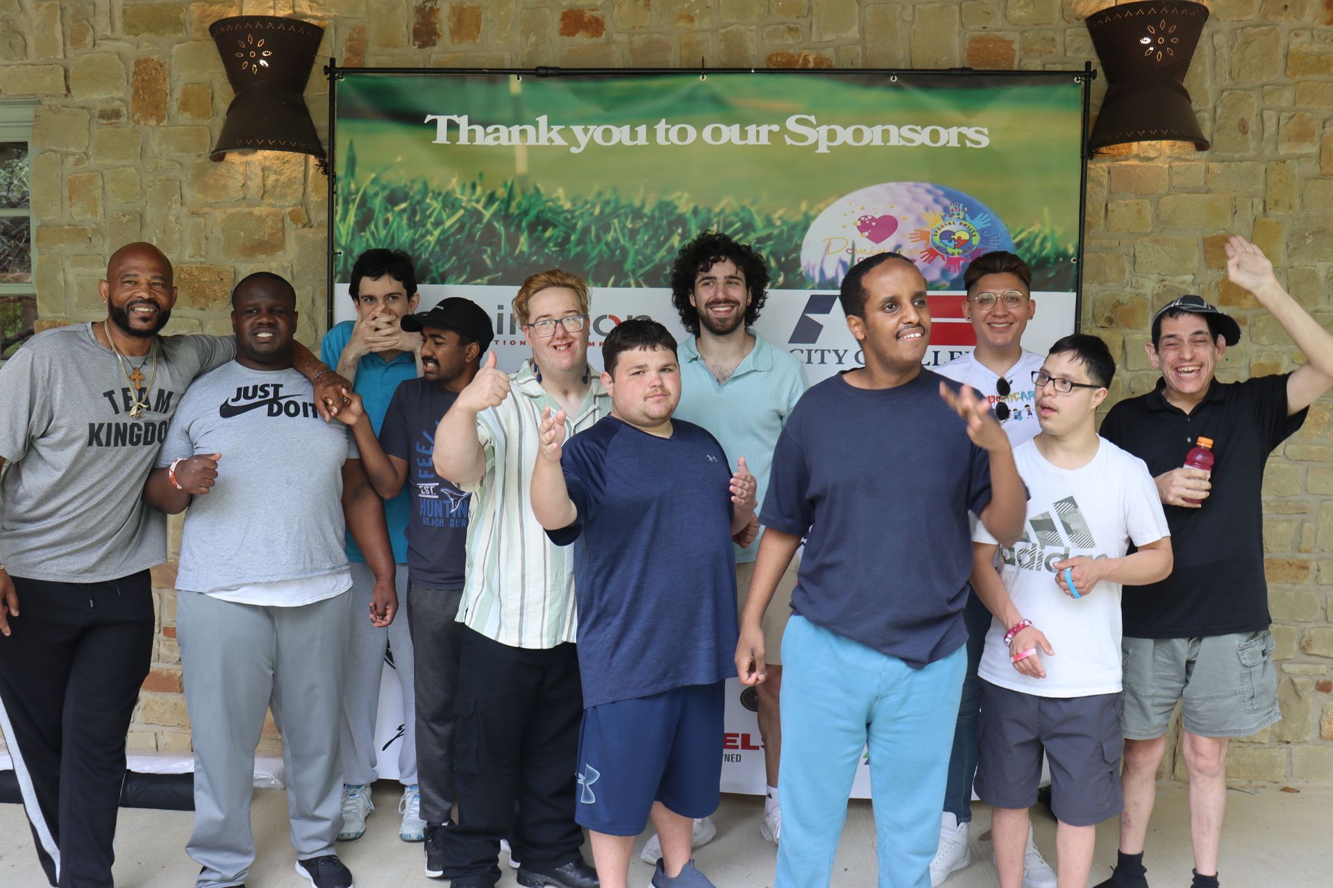 Group of people smiling and posing in front of a 