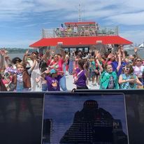 A group of people are standing on top of a boat.