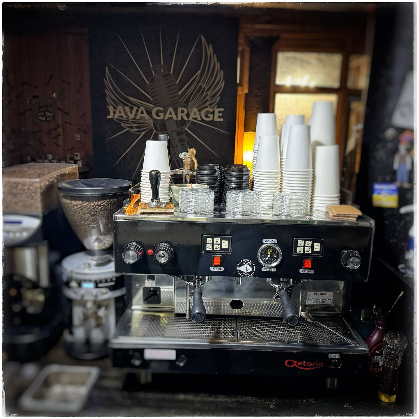 A coffee machine in front of a sign that says java garage