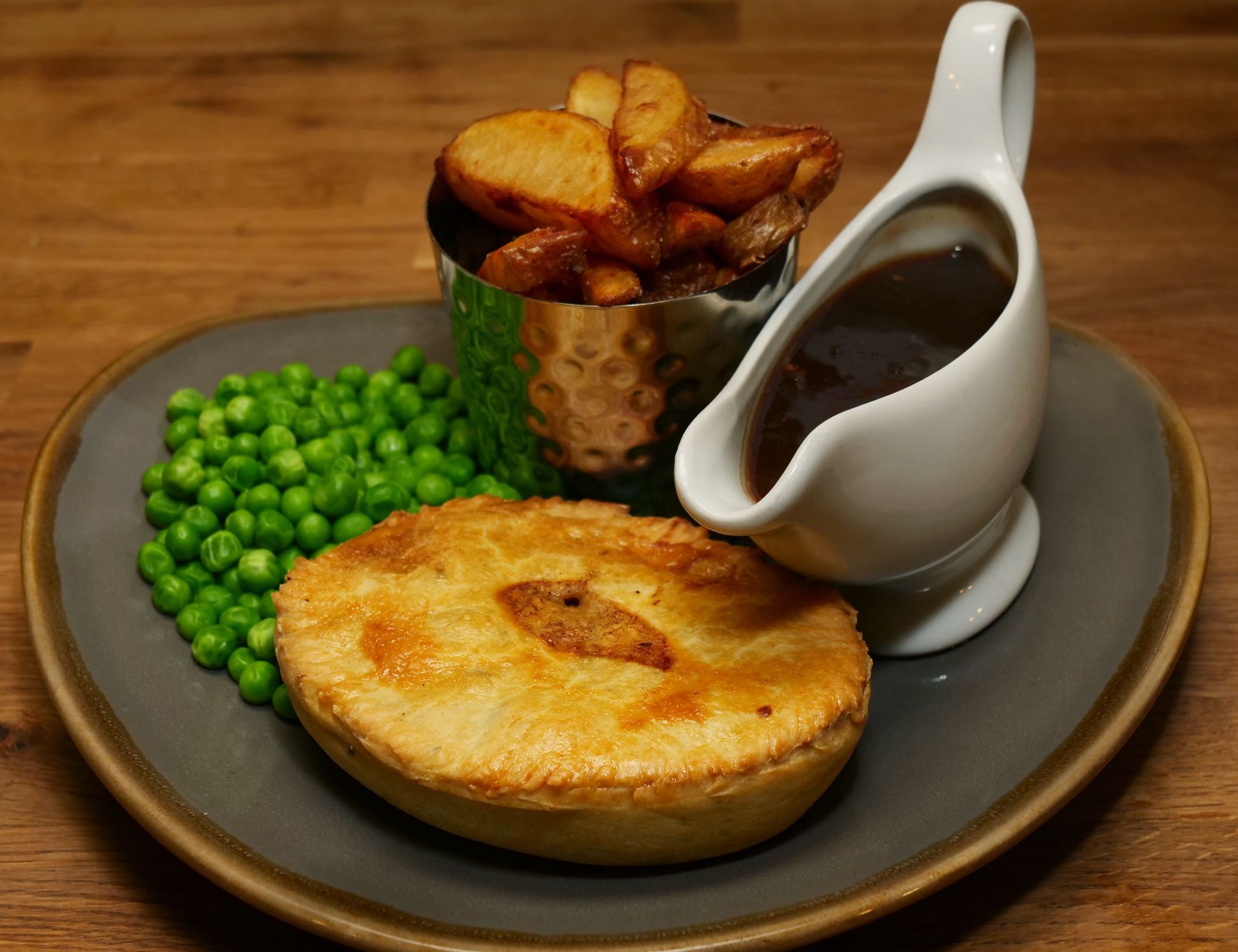 A pie with peas and gravy on a plate