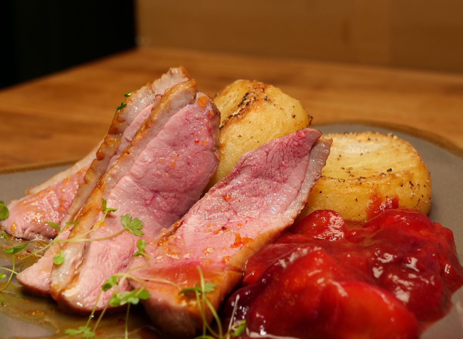 A close up of a plate of food with meat and potatoes on a table.