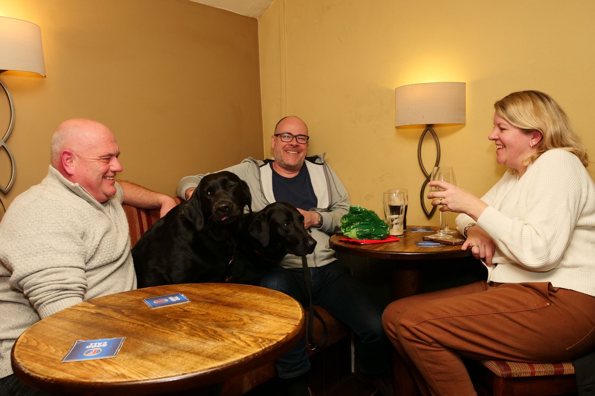 A group of people are sitting at a table with a dog.