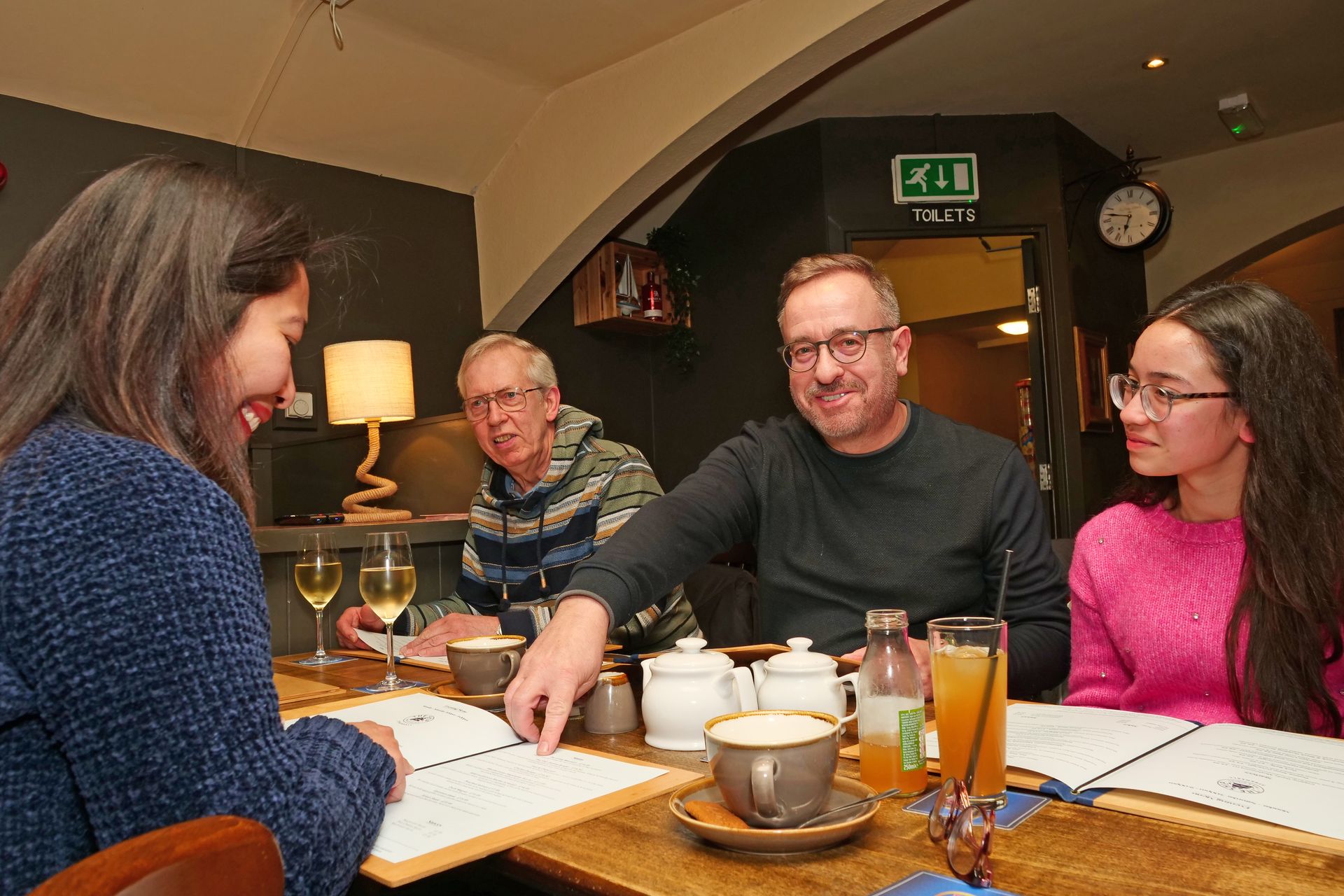 A group of people are sitting at a table in a restaurant.