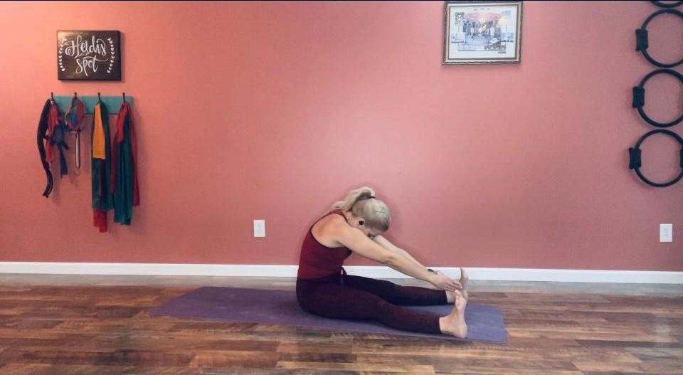 a woman is sitting on a yoga mat in a room .