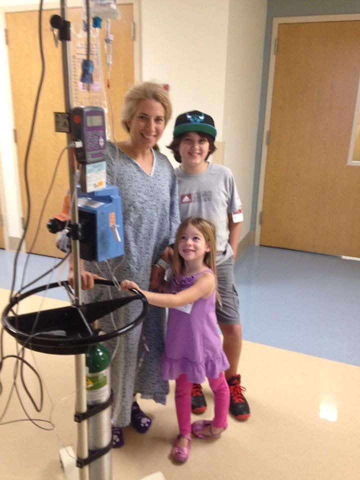 A woman and two children are standing in a hospital room