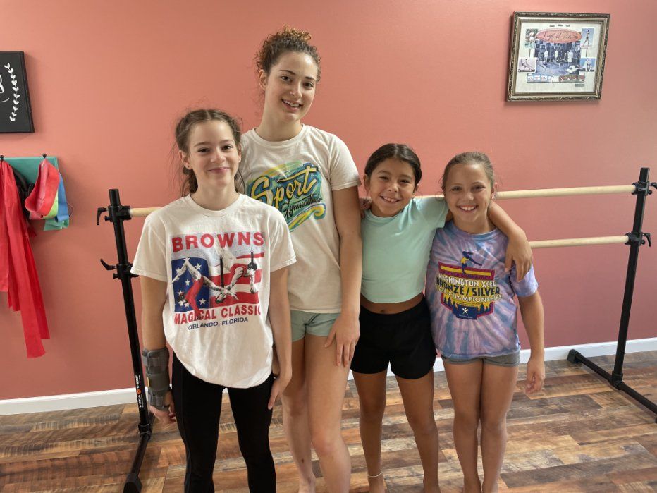 a group of young girls are posing for a picture in a dance studio .