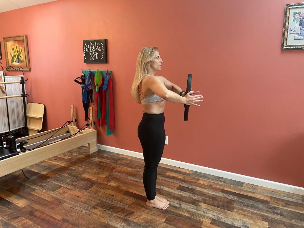 a woman is standing in a room with a pilates machine .