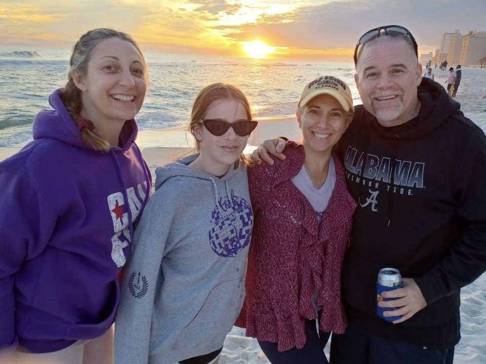 a group of people are posing for a picture on the beach .