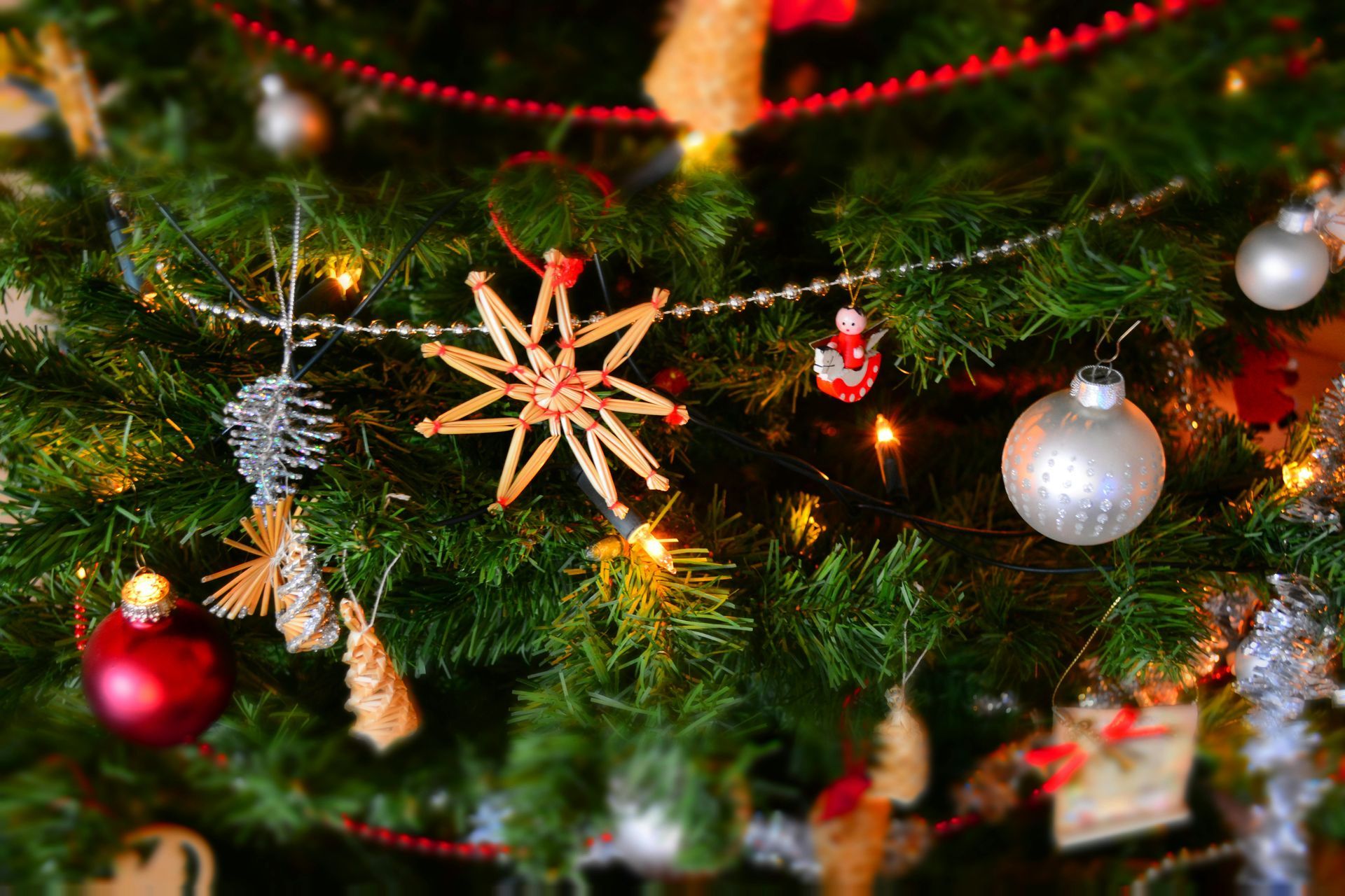 A close up of a christmas tree with decorations and lights.