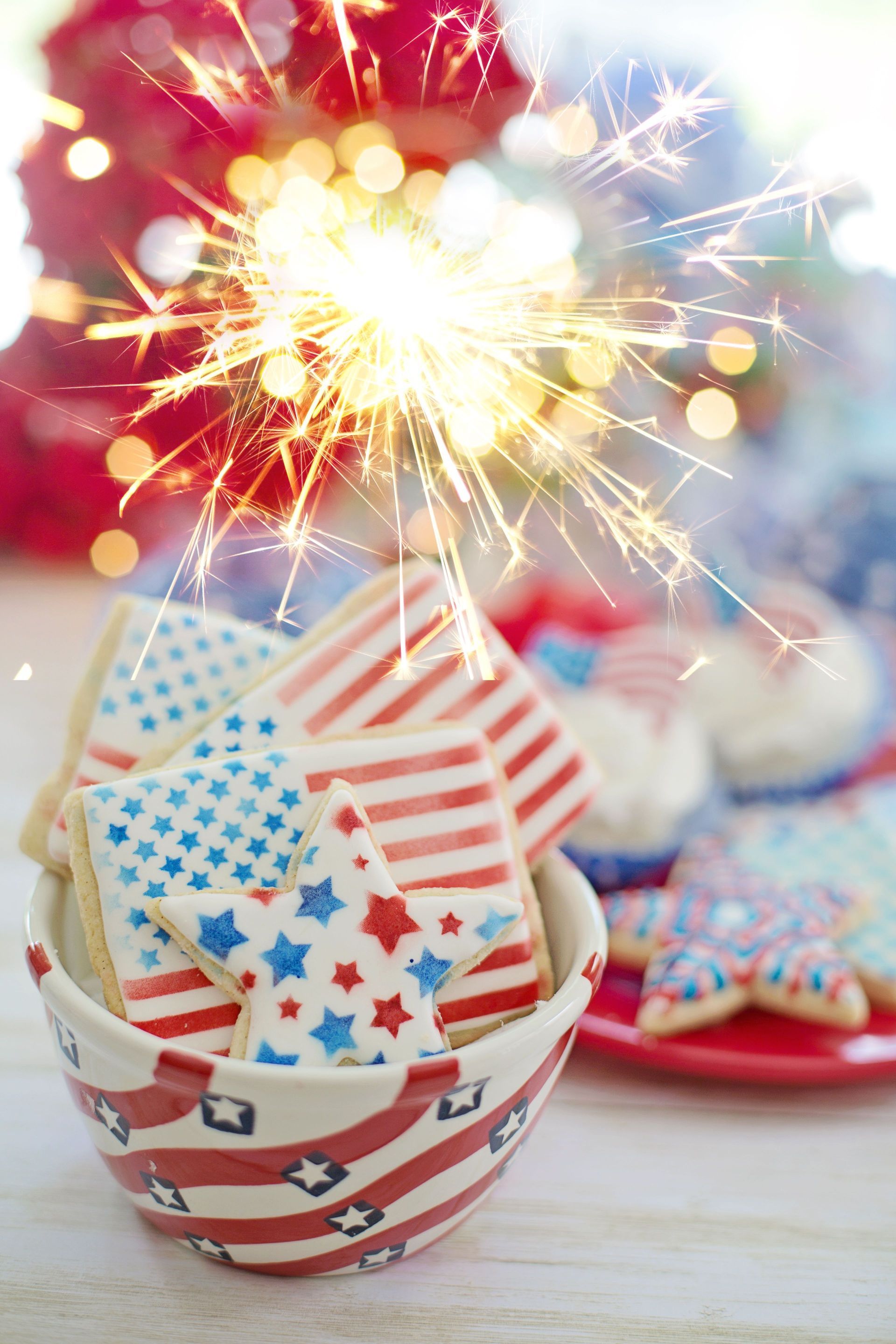 Patriotic striped and star-spangled cups with sparklers on a festive table