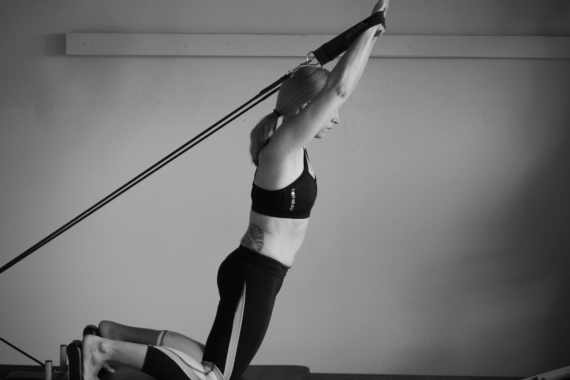 a woman is doing exercises on a pilates machine in a black and white photo .