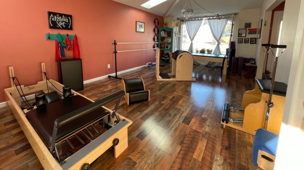 A pilates studio with wooden floors and a pilates machine.