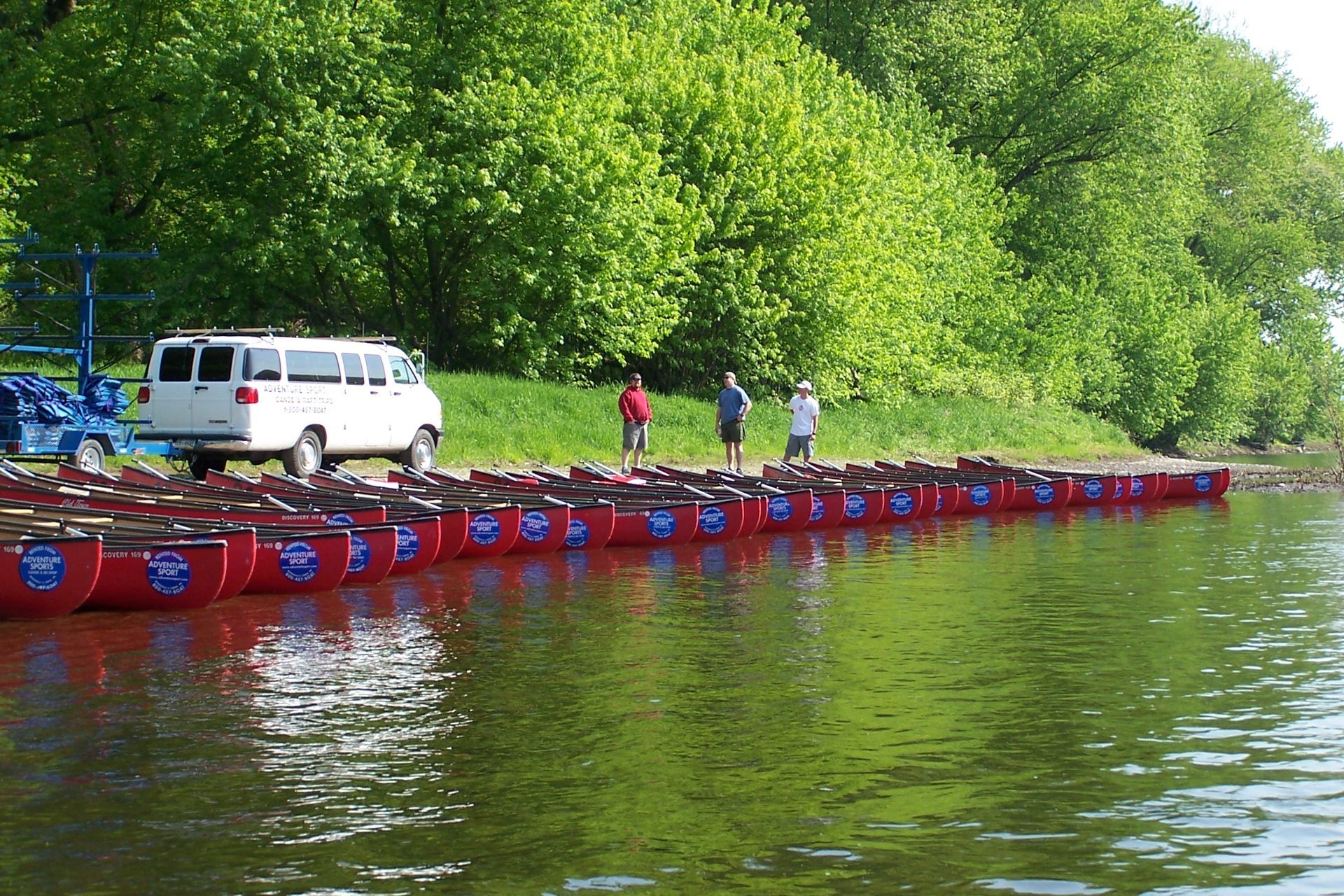 A white van is parked on a raft in the water  at adventure sports