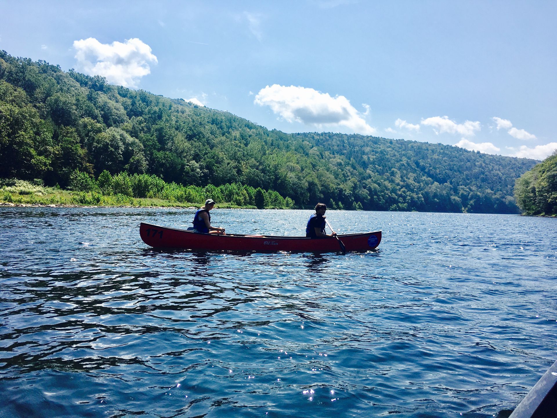 Two people in a red adventure sports canoe on a lake