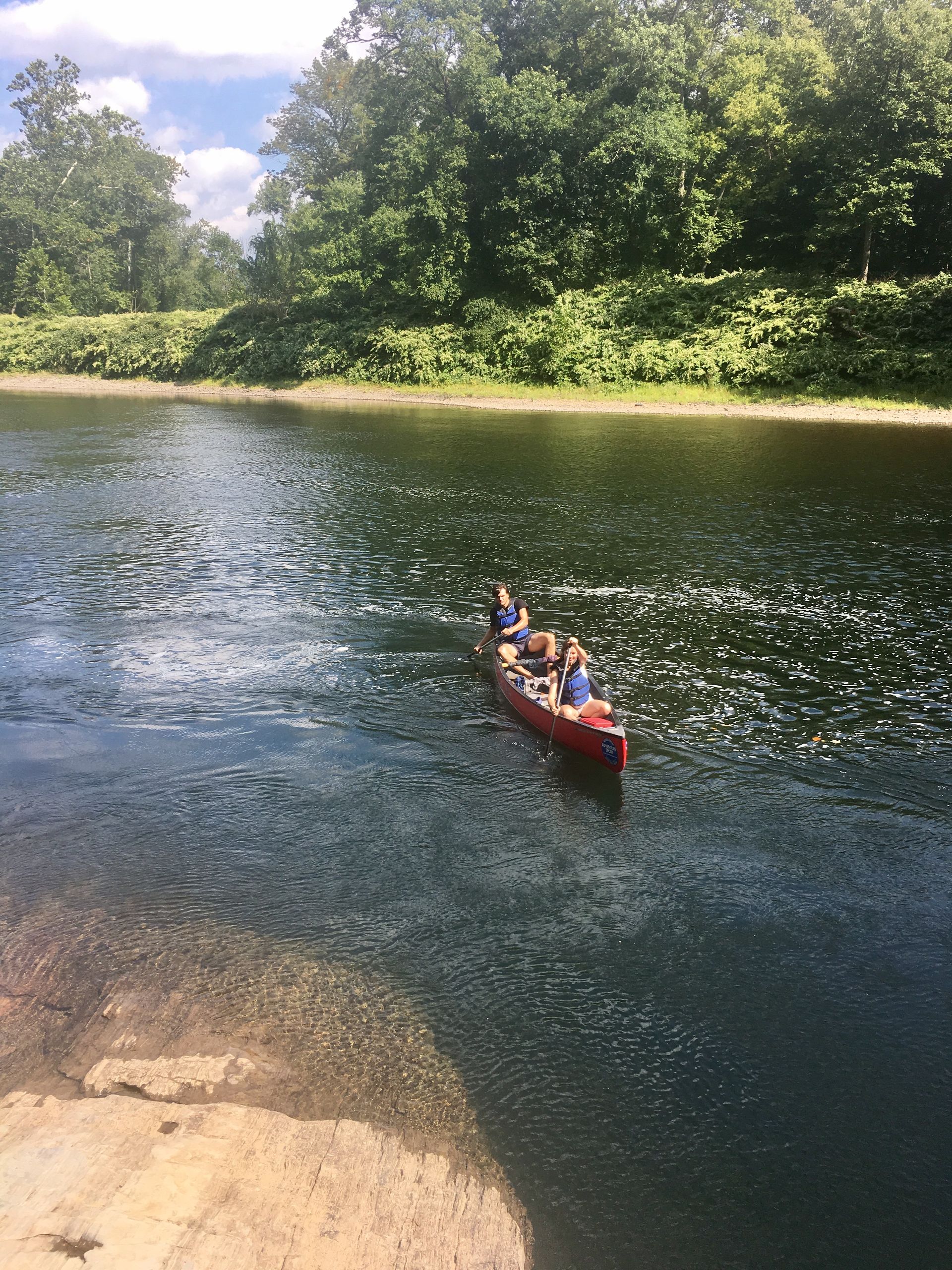 A group of people are rowing an adventure sports canoe down a river.