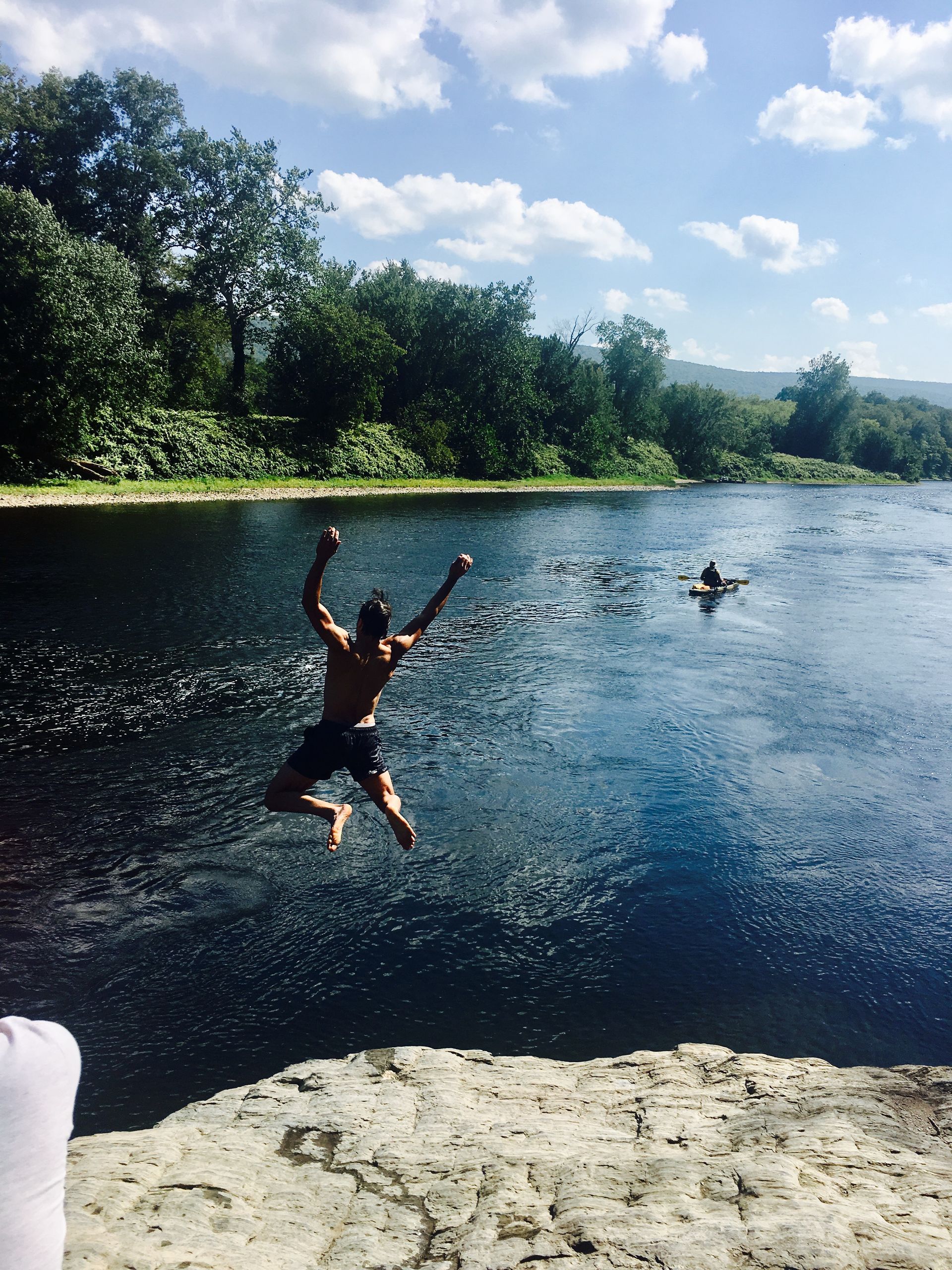 A man is jumping into the Delaware River