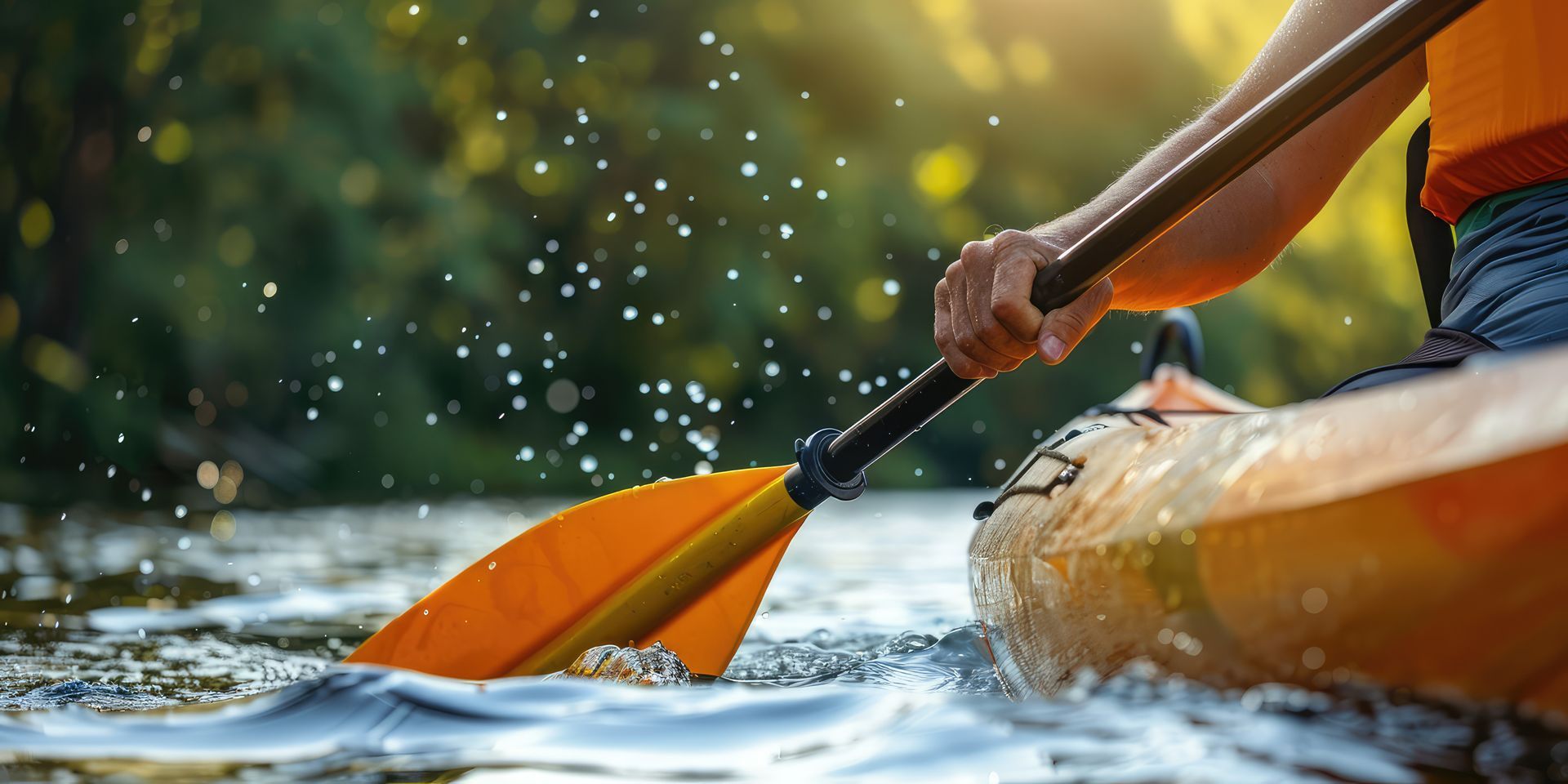 Kayaker paddling an orange kayak through splashing water on a river