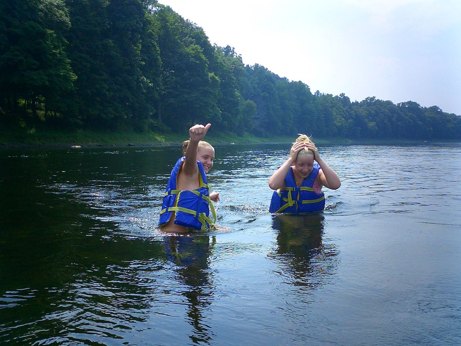 Two people wearing life jackets are swimming in the Delaware river