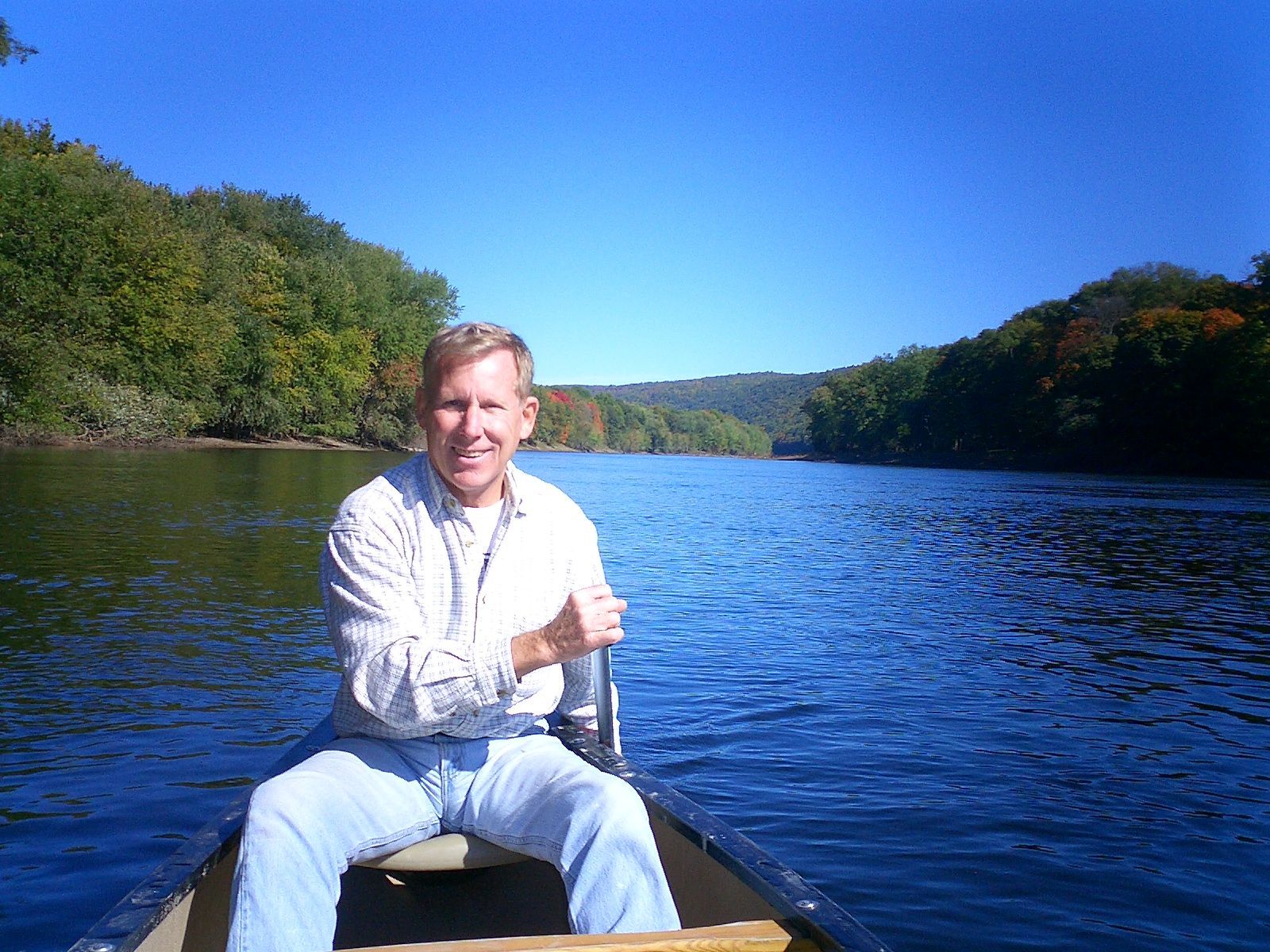 A man is sitting in a canoe on a lake  at adventure sports