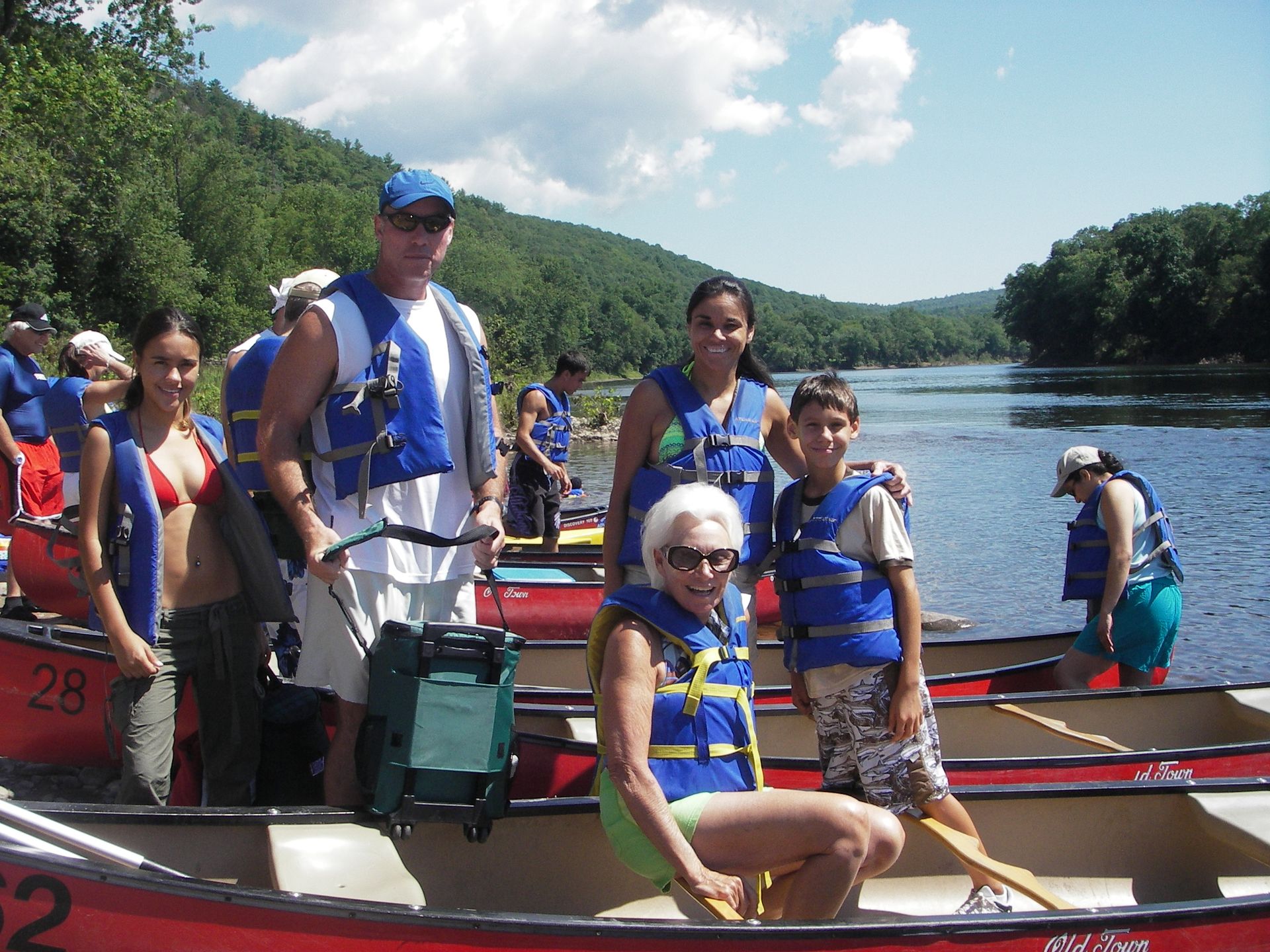 A group of people are in an adventure sports canoe with the number 52 on it