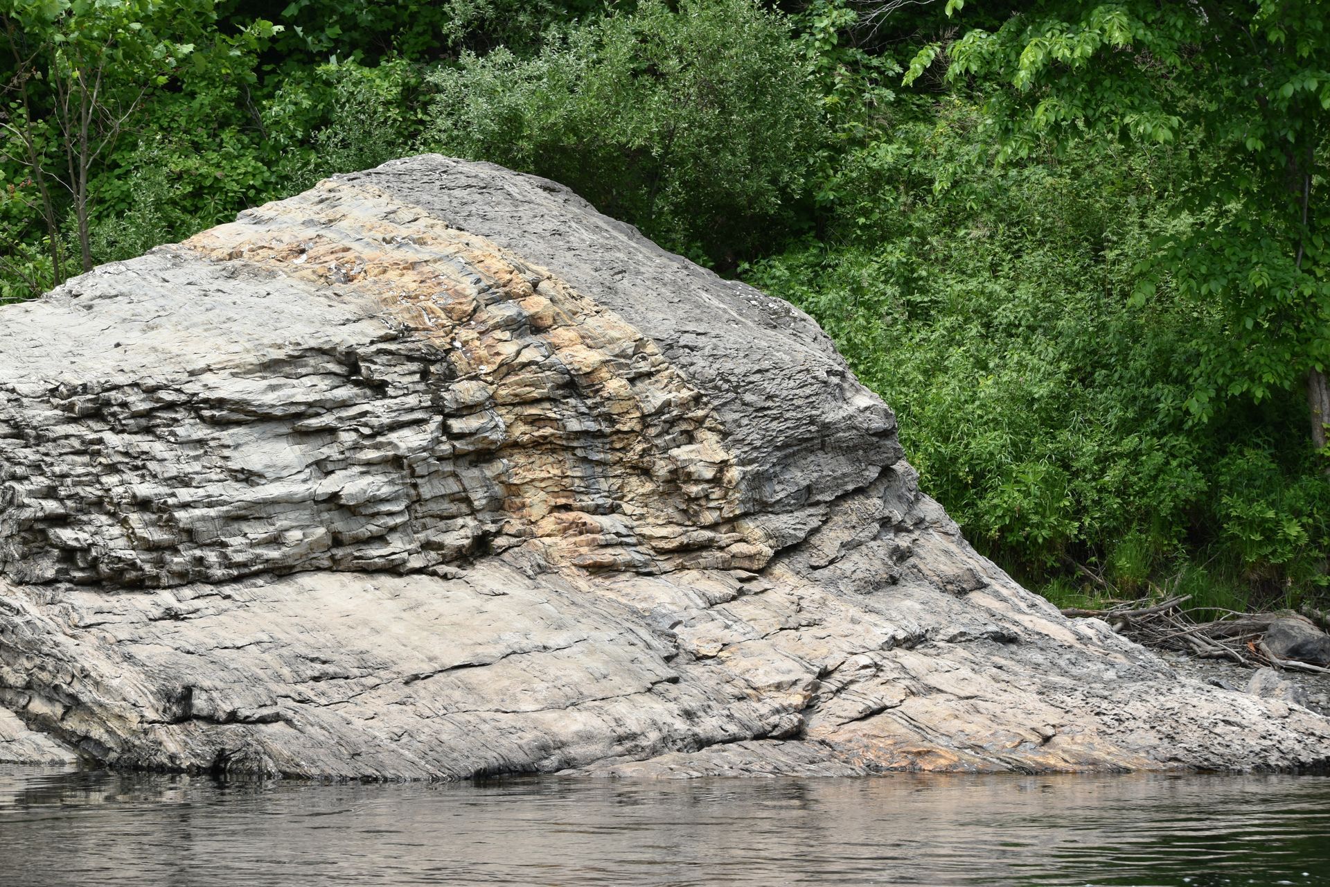 A large rock in the middle of a body of water