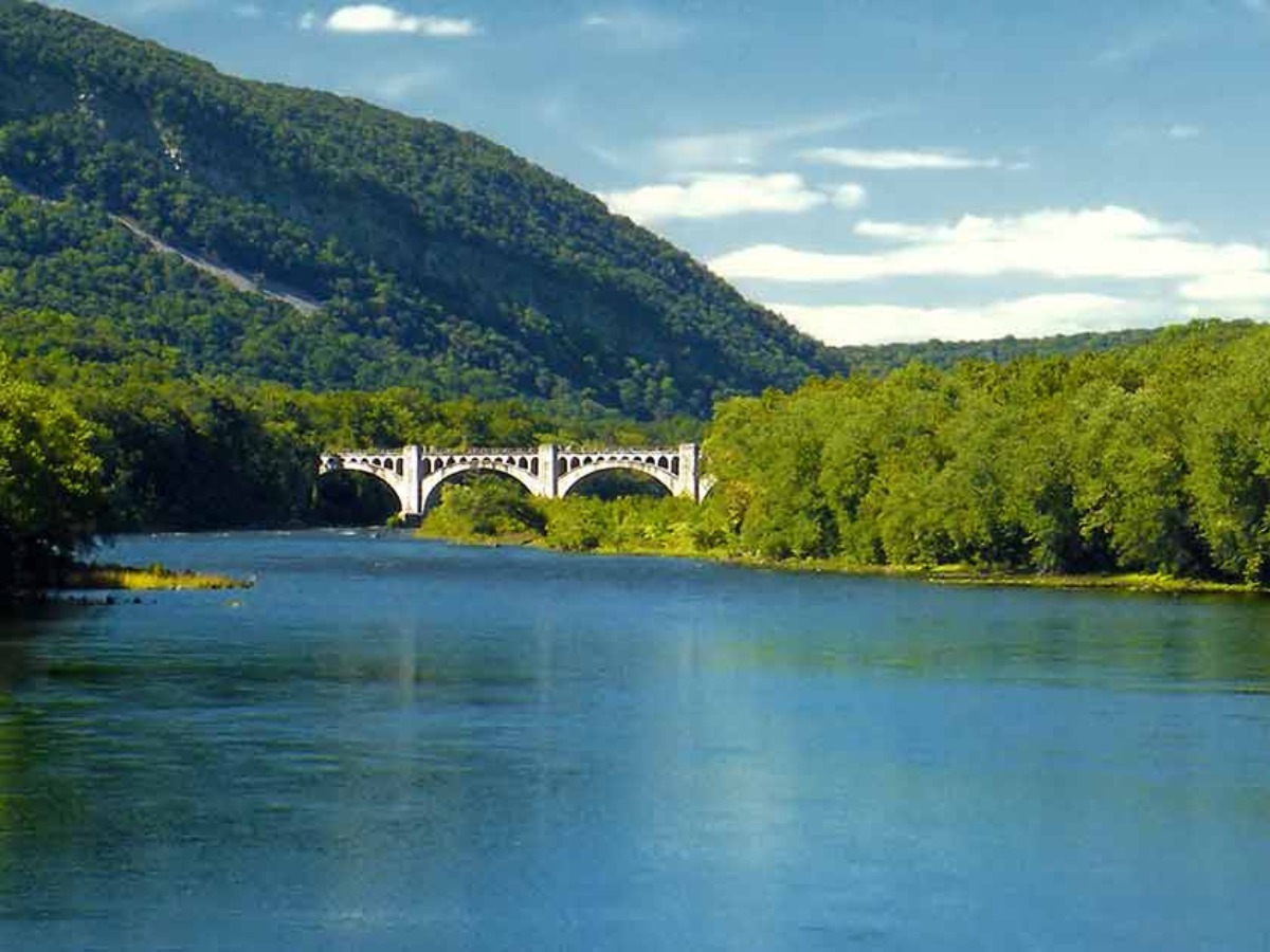 A bridge over a river with mountains in the background