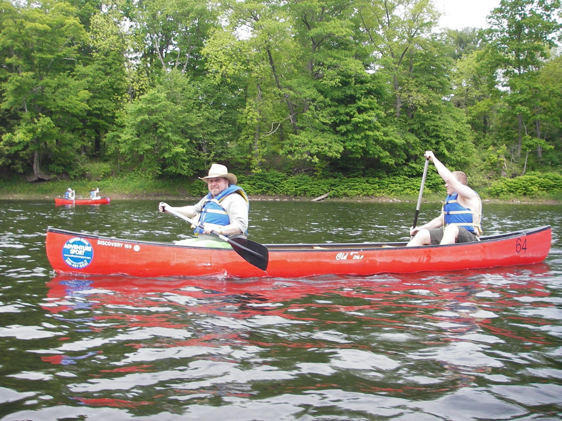 Two people in a red adventure sports canoe on a lake