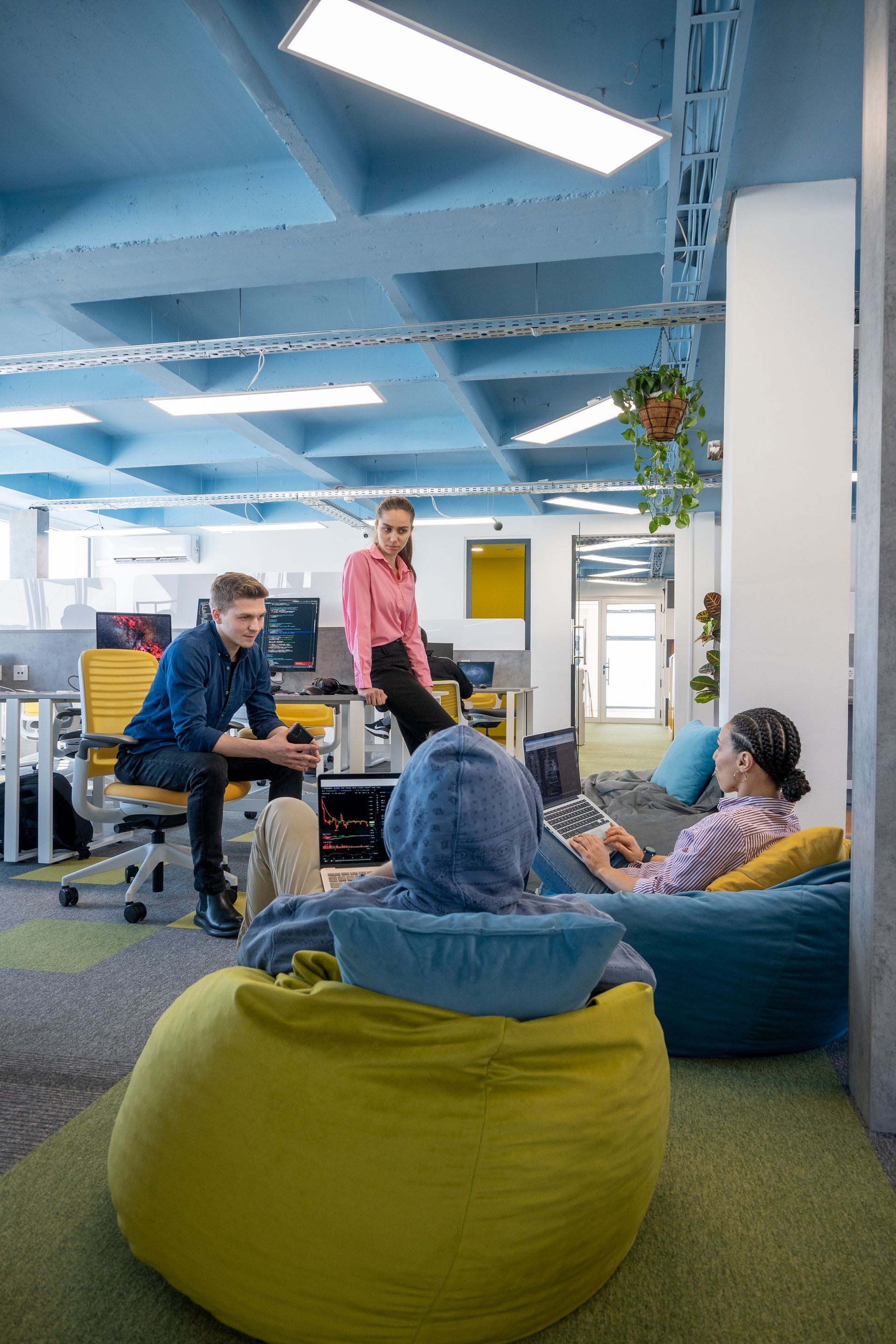 Office interior: people in casual settings, beanbags, desks, colorful modern design.