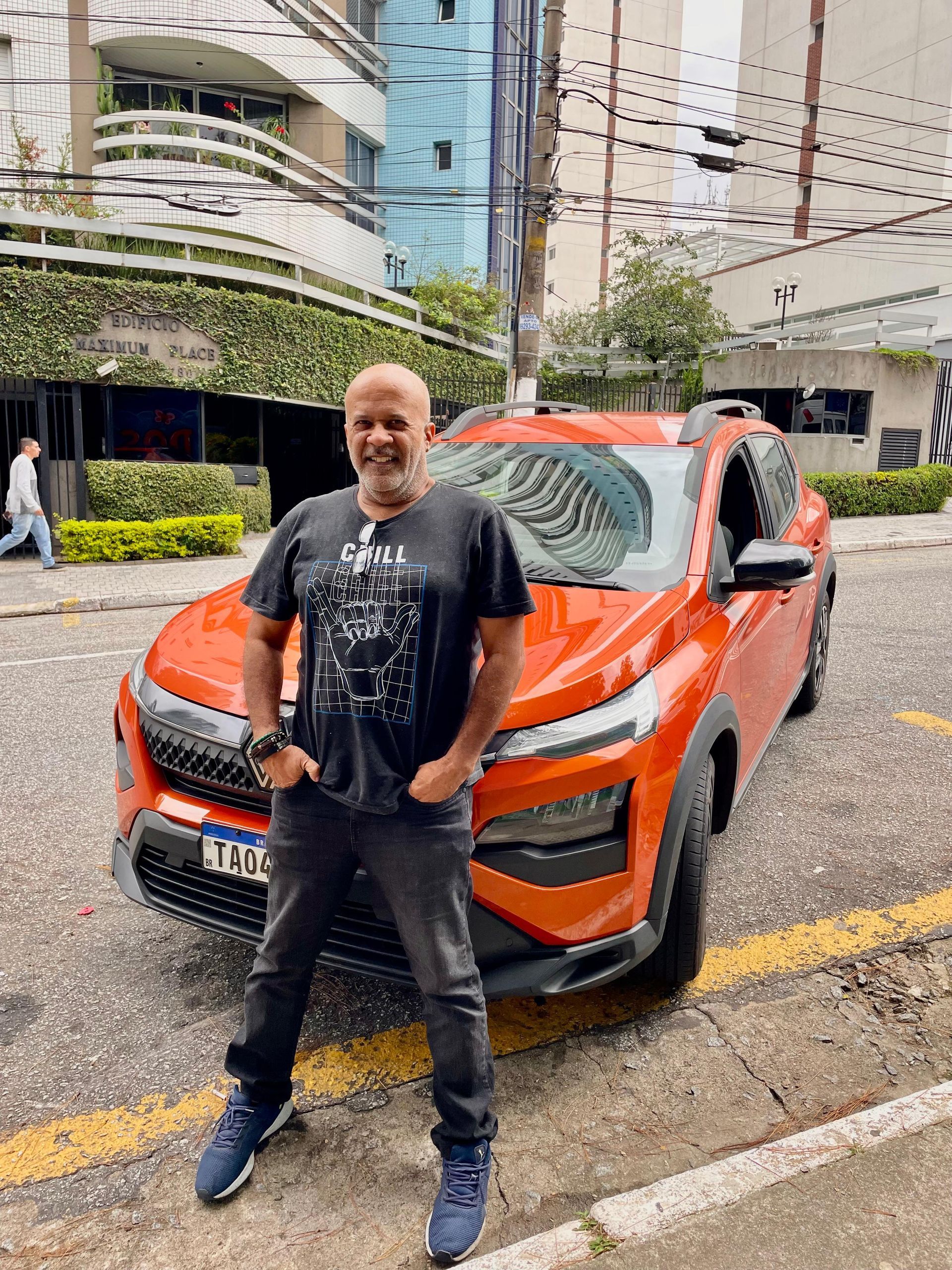 Wandick Donett is standing in front of an orange car Renault Kardian MT 2025.