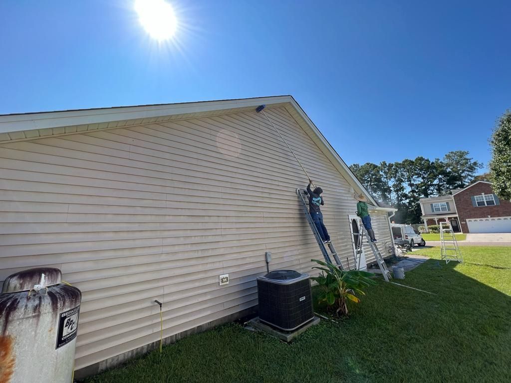A man is painting the side of a house.