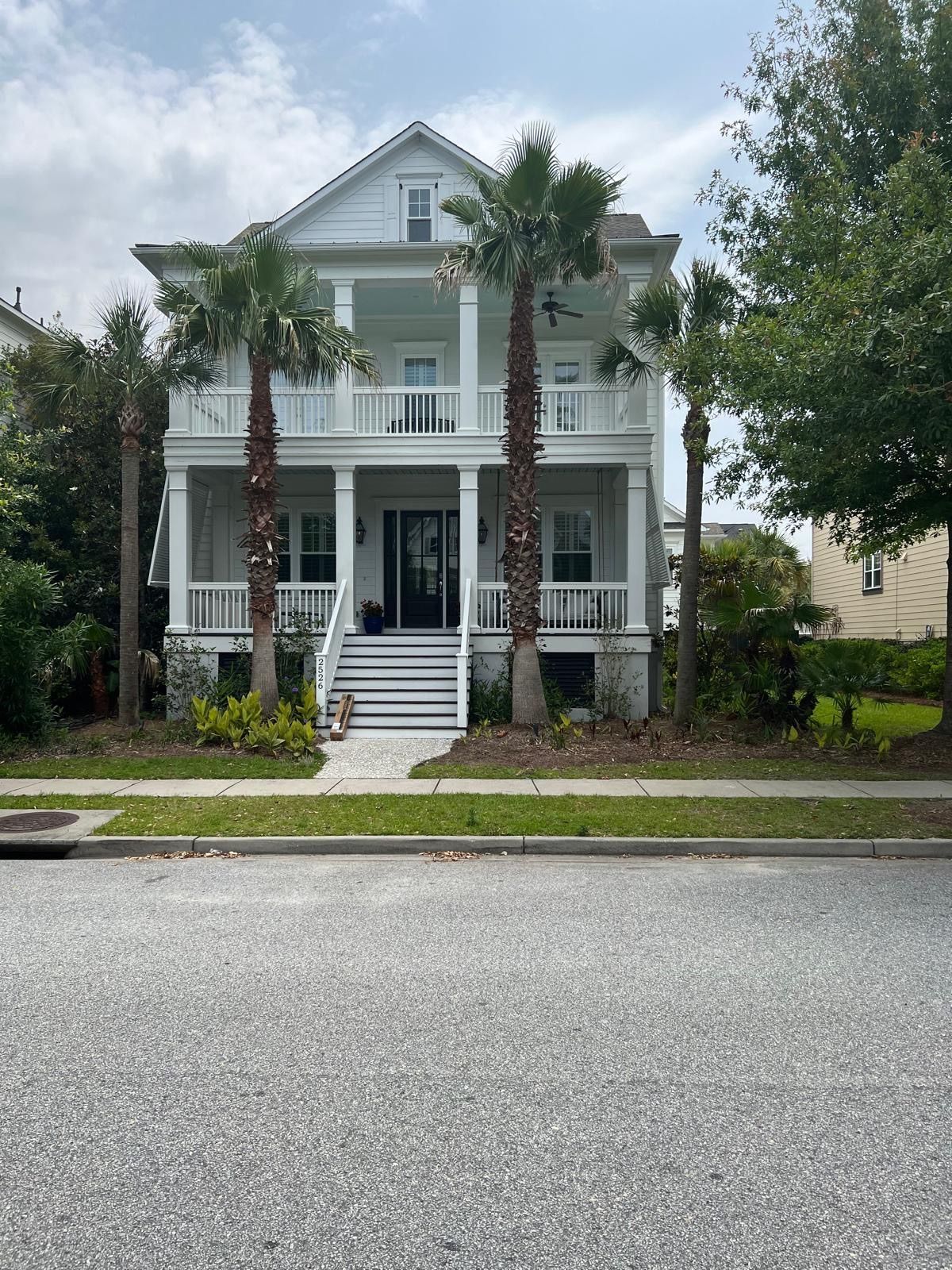 A large white house with palm trees in front of it