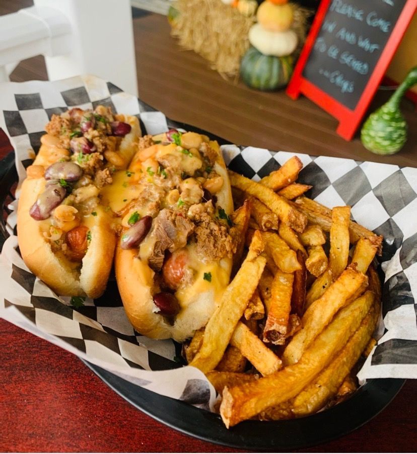 Two hot dogs and french fries in a basket on a table