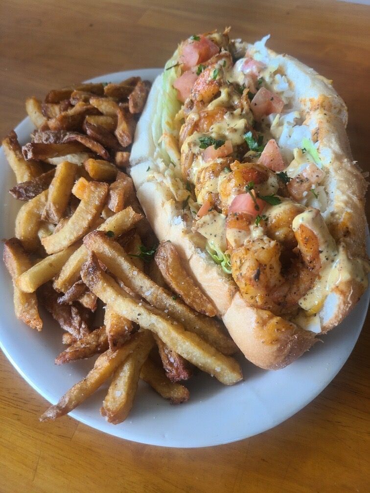 A plate of food with a sandwich and french fries on a table.